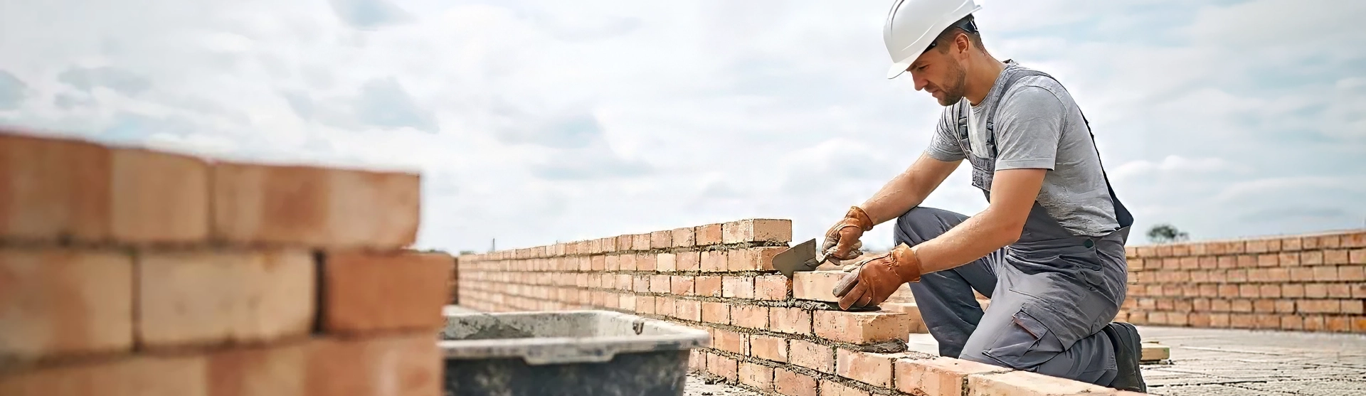 Maurer beim Bau einer Ziegelmauer auf einer Rohbau-Baustelle